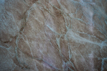 A stone wall with a rough texture and a blue hue. The stone is worn and has a weathered appearance.
