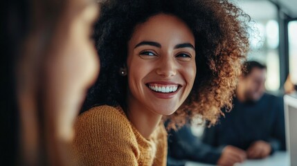 Close up of office workers collaborating and smiling around a computer screen set against a contemporary office backdrop