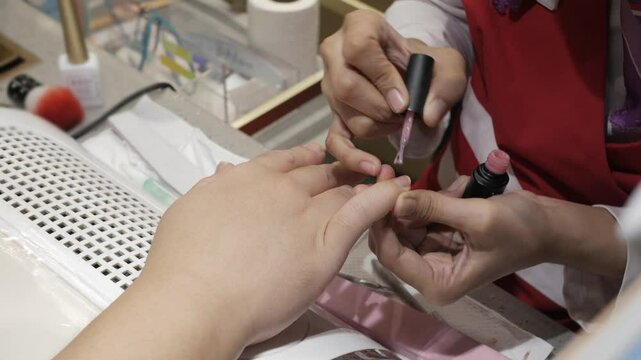 close up to hand while professional staff Manicure nail fingernails paint in hand beauty salon manicure, close up while hand finger nails treatment