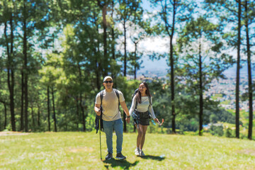 Young Happy Couple Hiking in the Nature Forest Loking direction and enjoying national park trekking