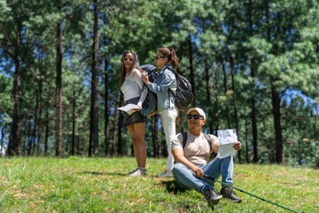 Fototapeta premium Three Young Friends Hiking in Nature Forest Happy looking for directions Trekking in National Park