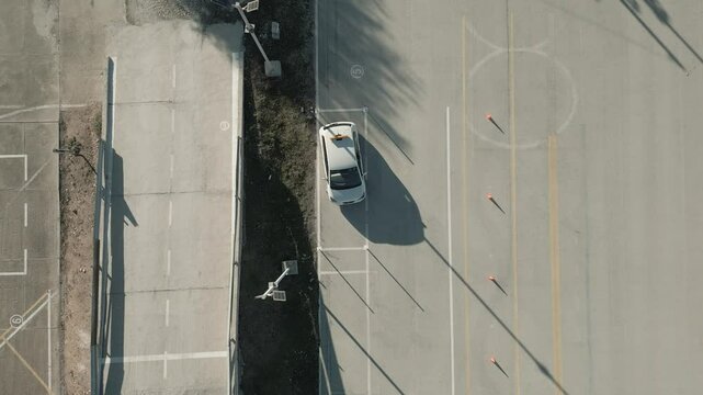 Aerial view of a car parallel parking in a driving test center. Vehicle driving training school.