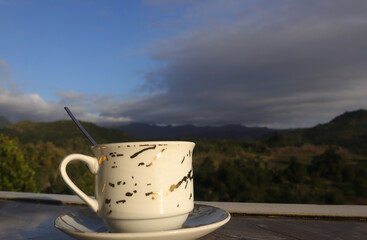 empty coffee cup on mountain nature landscape background. Good luck in drinking coffee