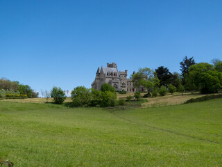 Panoramic view of de Ch&acirc;teau d'Abbadie surrounded by an impressive landscape typical of the French countryside on a sunny day with clear skies.