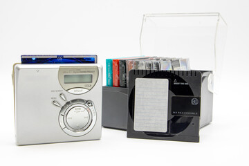 close-up of a minidisc player and recorder next to some minidiscs isolated on white background