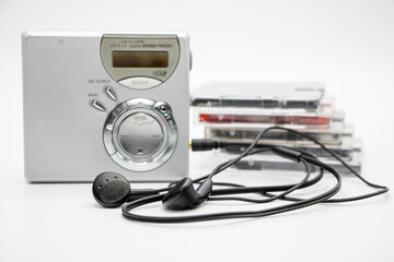 Close-up of a minidisc player and recorder with headphones and a minidisc disc isolated on white background