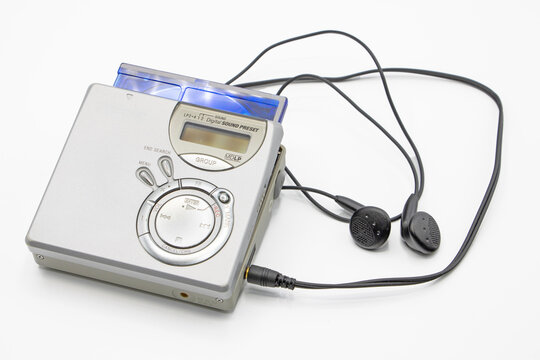 Close-up of a minidisc player and recorder with headphones and a minidisc disc isolated on white background