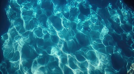 Deep blue water with blurred ripples, gentle waves on the surface, and soft sunlight reflections creating a calm mood.