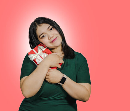 Photography young woman santa chubby beautiful asian one person standing smile cheerful happiness enjoy on theme chrimas eve, new year birhday hand holding box gft on isolated orange blackground