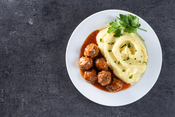 Meatballs with mashed potatoes on black slate background. Top view. Copy space