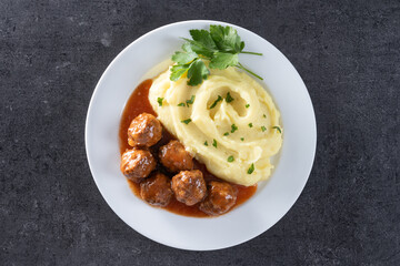 Meatballs with mashed potatoes on black slate background. Top view