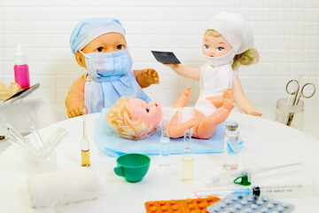 Toy doctor and doll nurse under treatment of sick little doll