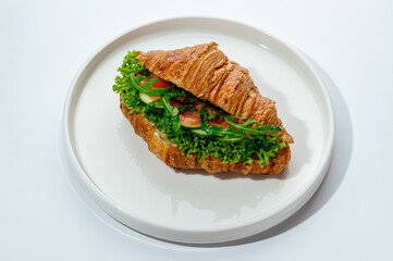 croissants stuffed with ham and vegetables on a white background