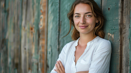 Fototapeta premium Portrait of young blonde business woman in white shirt standing in front of wooden wall smiling looking into camera. Copy paste empty place for text