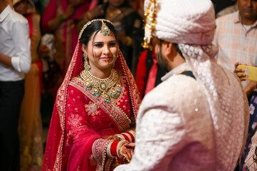 A bride and groom in traditional Indian wedding attire during their wedding ceremony