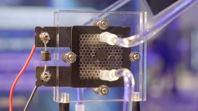 Hydrogen gas bubbles forming on the membrane of an electrolyzer, splitting water into hydrogen and oxygen using electric energy. Closeup,