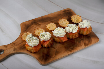 The process of preparing the snack. Profiteroles are filled with salted trout and cream cheese