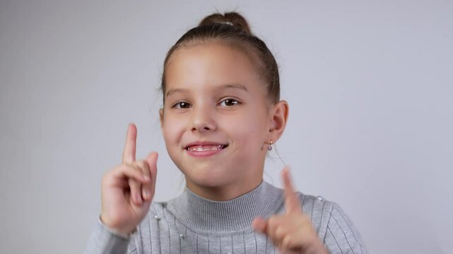 Cute girl dancing, smiling looking at camera, close-up. Child with dental braces dance fool around have fun gesticulating with hands enjoy relax