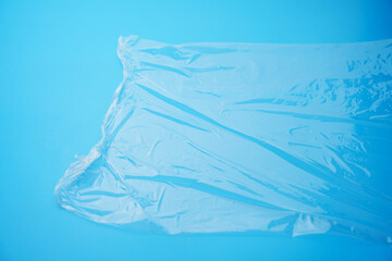 Transparent stretch film for packaging on a blue background. material for storing food and objects. household trifles.