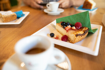 tavolo di legno con tazze di caffè espresso e fette di crostata con frutta