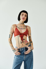 A confident woman presents her unique fashion and tattoos in a bright setting.