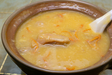 angle view fresh cordyceps flower chicken porridge in clay pot at horizontal composition