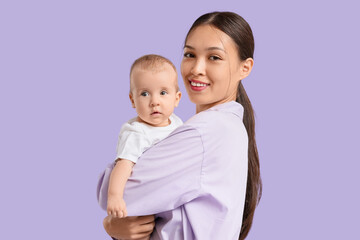 Beautiful young happy Asian mother with her cute little baby on purple background