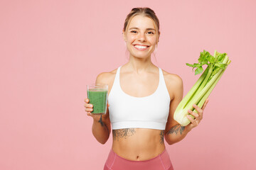 Young smiling happy woman wear white top casual clothes hold glass of celery root smoothie isolated...