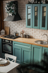 Stylish kitchen interior featuring mint green cabinets and festive decoration