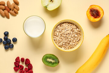 Tasty breakfast with oatmeal, milk and fruits on beige background
