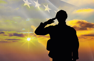 Silhouette of a soldier with a background of the Kosovo flag and a sunset or sunrise. Concept of national holidays. Commemoration Day.