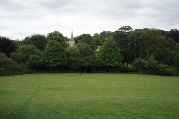 Scenic valley view of a green farmland field and cloudy sky above