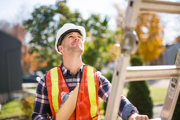 inspector or engineer with ladder checking the building structure and house roof specifications. © Louis-Paul Photo