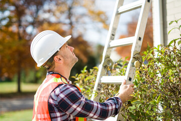 inspector or engineer with ladder checking the building structure and house roof specifications. © Louis-Paul Photo