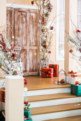 Festive holiday decorations with gifts near a rustic wooden door in December