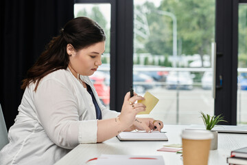 Obraz premium A focused professional outlines her ideas and notes diligently in a well designed office space.