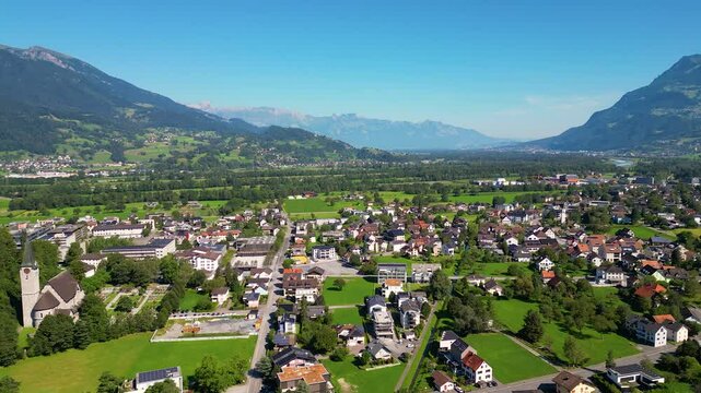 High angle Drone Point of View on the Village of Balzers, Liechtenstein, on summer day, flying sideways