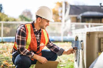 technician working on air conditioning or heat pump outdoor unit