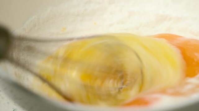 Egg beater beating eggs close-up slow motion