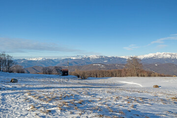 ampia vista panoramica su un ambiente naturale innevato, tra colline e montagne selvagge, nella...
