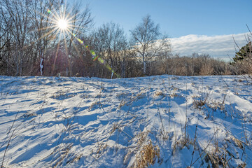 Obraz premium ampia vista panoramica su un ambiente naturale innevato, tra colline e montagne selvagge, nella Slovenia occidentale, di mattina, in inverno, sotto un cielo completamente sereno