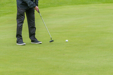 Golfer putting on a green course during a game