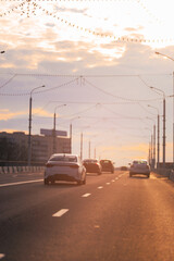 Autumn landscape and view of the road with cars. Orange evening sun and reflections on cars.
