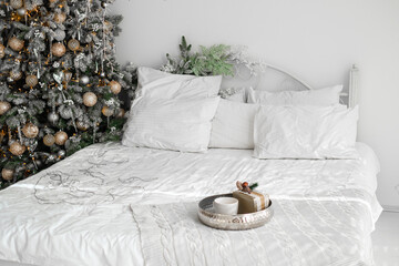 Cozy Christmas bedroom decorated with a tree and festive touches