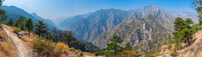 Obraz premium A panoramic view of a mountain range with a clear blue sky