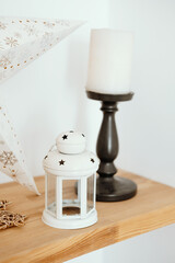 Decorative lantern and candle holder on wooden shelf with star-themed decor