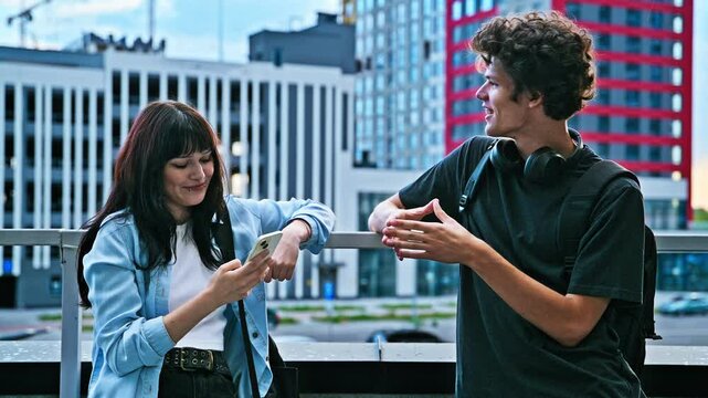 Teenage friends college students guy and girl talking, standing outdoor, urban style