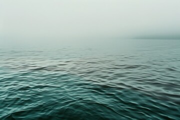 Obraz premium A serene view of rippling water in a misty ambiance, showcasing calm and an endless horizon that evokes a profound sense of tranquility.