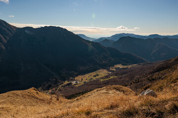 vista panoramica guardando dall'alto una vallata e varie catene montuose boscose, nelle Alpi nel...