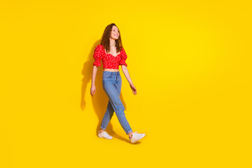 Full size photo of pretty young girl look empty space walking black friday wear trendy red outfit isolated on yellow color background